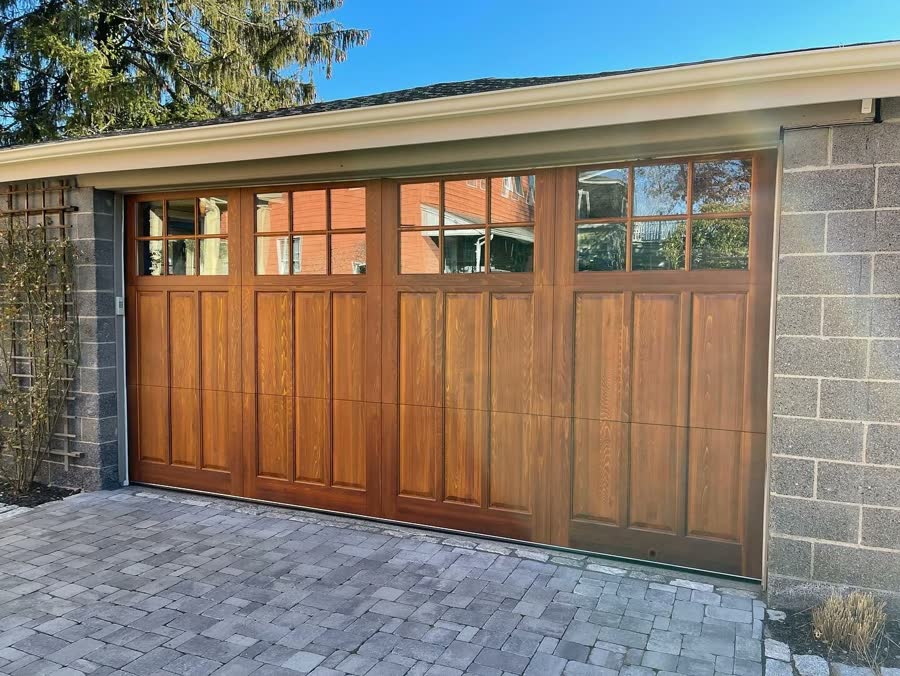 Wood carriage door with window lites above a paved driveway