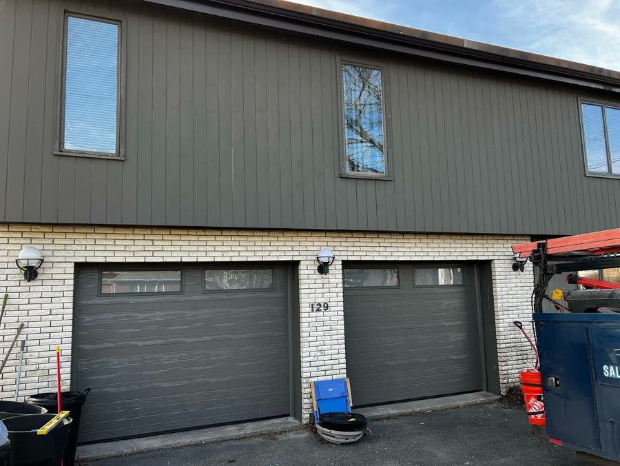 Two dark commercial garage doors on a light brick building